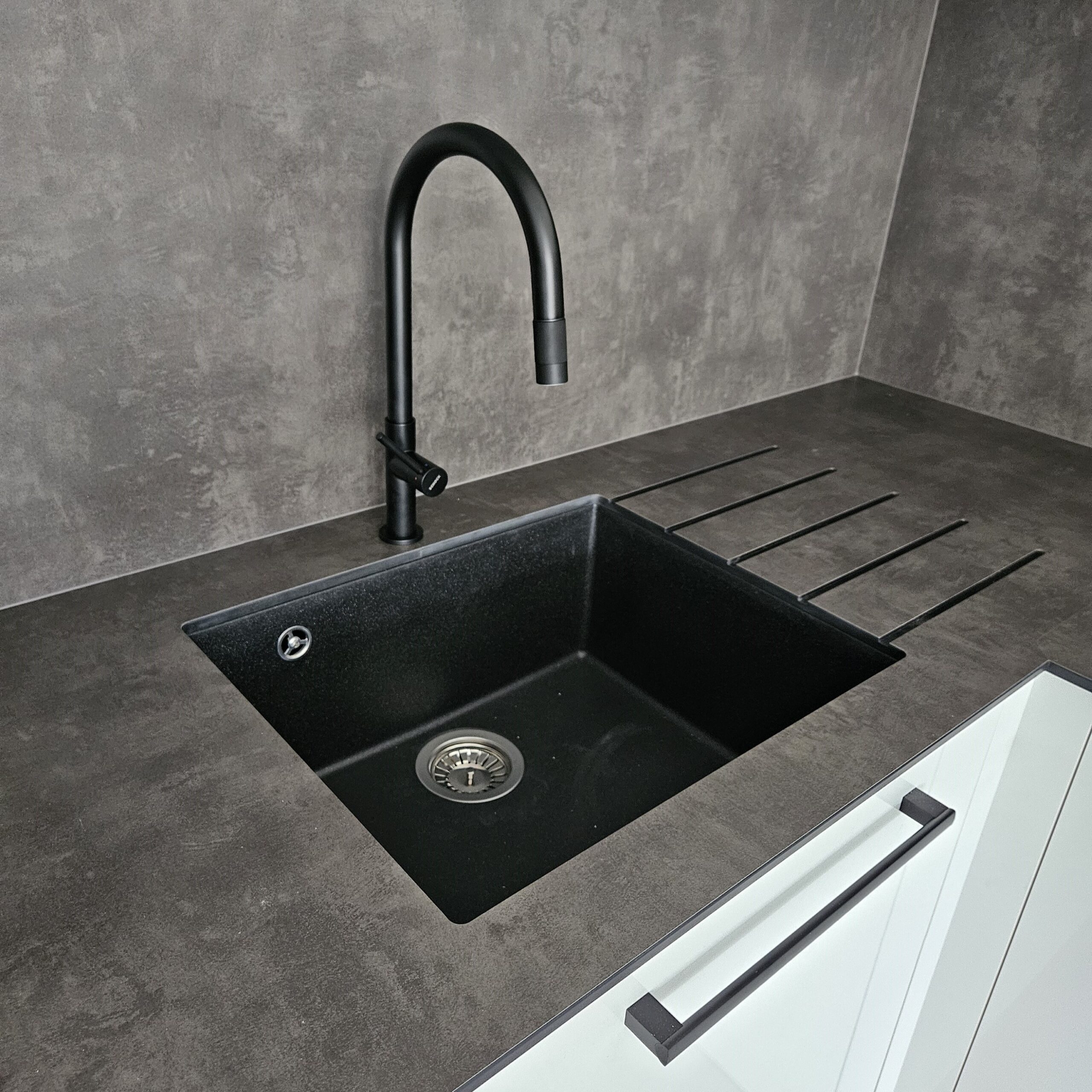 Realizace moderní kuchyně na míru pro klienta v Hanychově – Liberec. Velmi moderní kuchyňská linka, v které dominuje hlavně bílý lesk. Pracovní deska a zadní obklad jsou z kompaktní desky odstínu Agate Grey čímž dodává kontrast s bílým leskem. Kuchyně je také vybavena velice kvalitním kováním od firmy Blum jak je u nás standart. Díky CNC technologii jsou do pracovní desky vyfrézované drážky pro odvod vody do dřezu. Toto velice zajímavé řešení máme zároveň vystavené na našem novém showroomu v Jablonci nad Nisou.