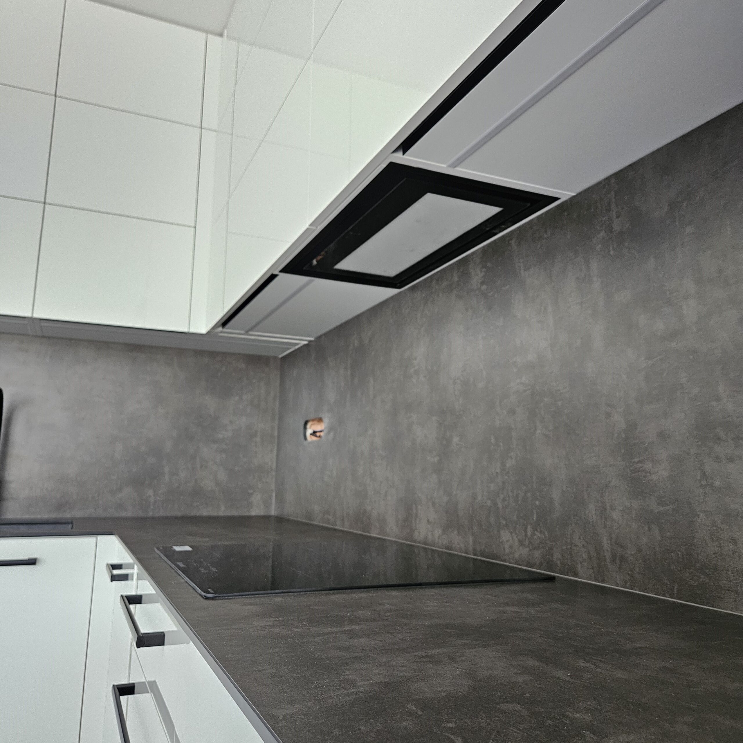 Realizace moderní kuchyně na míru pro klienta v Hanychově – Liberec. Velmi moderní kuchyňská linka, v které dominuje hlavně bílý lesk. Pracovní deska a zadní obklad jsou z kompaktní desky odstínu Agate Grey čímž dodává kontrast s bílým leskem. Kuchyně je také vybavena velice kvalitním kováním od firmy Blum jak je u nás standart. Díky CNC technologii jsou do pracovní desky vyfrézované drážky pro odvod vody do dřezu. Toto velice zajímavé řešení máme zároveň vystavené na našem novém showroomu v Jablonci nad Nisou.